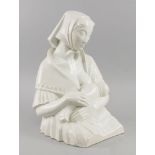A Continental white glazed ceramic model of a young lady feeding her baby, early 20th century,