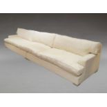 A large modern sofa in two parts, of recent manufacture, with cream floral upholstery, having six