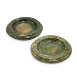 Two marble ash trays by Rolex, each of green stained marble and of circular form with applied