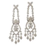 A pair of diamond pendent earrings, of tapered form, each with flowerhead within a shaped frame with