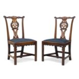 A pair of early George III and later mahogany side chairs, with foliate carved serpentine crest