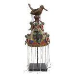 A Tribal headdress, Yoruba, Nigeria, of conical form with a bird finial at the top and bands of