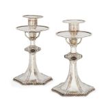 A pair of silver plated candlesticks in the manner of Omar Ramsden, the tapering stems to