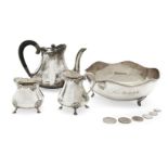 A three-piece Indian silver tea set, comprising a tea pot, milk jug and sugar pot, each raised on