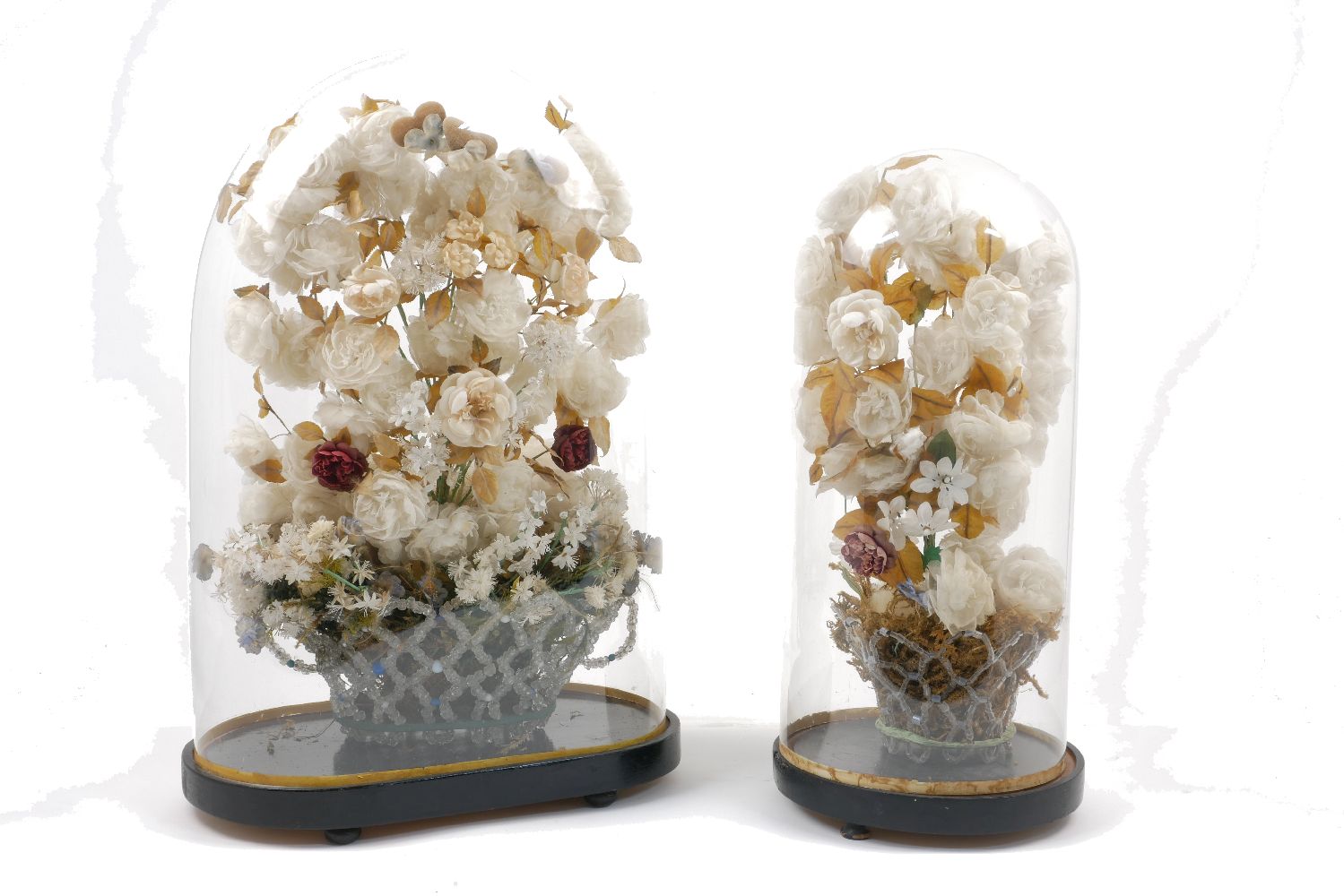 A Victorian silk flower arrangement, in a glass bead vase, under a large glass dome, with an