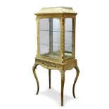 A French gilt metal mounted and silk vitrine, late 19th Century, the shaped cornice, above glazed