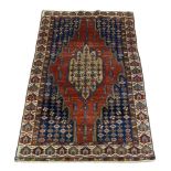 A Hamadan rug, early 20th Century, with pole medallion in red field, with ivory main border, 197cm x