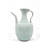 A Chinese yuan style celadon glazed ewer, with gently curving spout and reeded looping handle, the