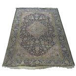 A Tabriz silk rug, mid/late 20th Century, with dusty pink medallion in deep blue floral decorated