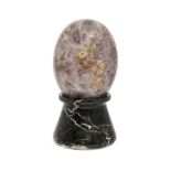 A Fluorspar specimen egg, 14cm high, on a black and veined marble stand (2)Please refer to