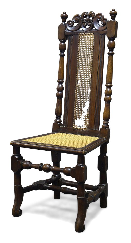 A stained beech and caned highback chair, 17th Century and later, the top rail with carved and