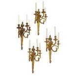 A set of four Louis XVI style three branch wall lights, 20th century, each with urn form finial to a