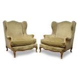 A pair of Louis XV style wingback armchairs, 20th Century, upholstered in green fabric with loose