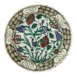 An Iznik pottery dish, Turkey, circa 1600, underglaze painted in raised red, cobalt blue, green