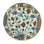 An Iznik pottery dish, Turkey, circa 1600, of shallow form, with sloping rim, underglaze painted