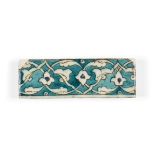 A Damascus Iznik tile, 16th century, of rectangular form, the turquoise ground decorated in white,