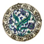 An Iznik pottery dish, Turkey, circa 1600, of deep form with sloping rim, underglaze painted in