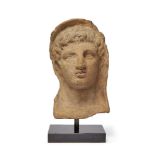 An Etruscan terracotta votive head of a young man, circa 3rd-2nd Century B.C., of hollow form,
