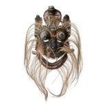 A wooden mask, Ceylon (Sri Lanka), circa 1900, with bulging eyes, movable jaw, three cobra heads