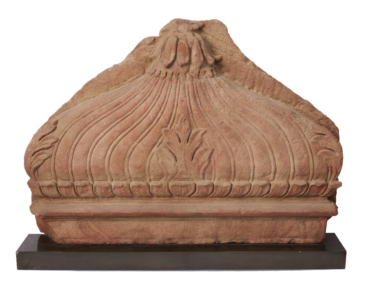 A red sandstone fragment of a dome, Mughal India, 17th century, carved with a lotus flower to top,