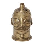 A brass head of Vishnu, India, 18th century, on a circular base, with wide, almond shaped eyes,