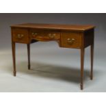 An Edwardian mahogany and crossbanded side table, the shaped top above three frieze drawers,