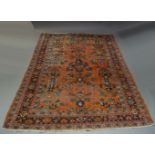 A Turkish carpet, early to mid 20th Century, the brick red field, boldly decorated with flowering