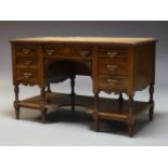 An Edwardian mahogany and inlaid kneehole desk, the rectangular top inset with tan leather writing