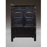 An oak court cupboard, 17th century and later, with two moulded panel cupboard doors, enclosing