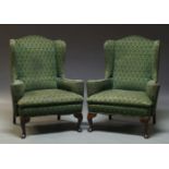 A pair of George II style wingback armchairs, late 20th Century, upholstered in green fabric, on