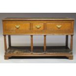 A George III oak dresser base, the rectangular plank top above one short and two long frieze