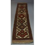 A Soumak runner, late 20th Century, with six medallions in ivory field, 390cm x 781cm, flat weave