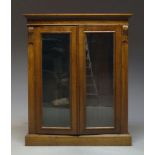 A Victorian mahogany bookcase cabinet, the moulded cornice above two glazed doors enclosing three