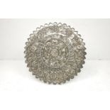A Turkish silver circular mirror, 19th century, with shaped outline, the back embossed with a
