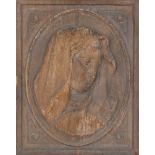 An Italian pressed wood plaque of the Madonna, 19th century, in oval with decorated floral
