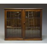 A rosewood and glazed bookcase, late 19th Century and later, the moulded top above two glazed doors,