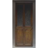 A Victorian mahogany cabinet, the moulded cornice above two leather embossed paneled doors,