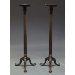 A pair of George III style mahogany torchère stands, 20th Century, the circular tops on fluted