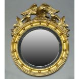 A giltwood wall mirror, 19th Century and later, with later carved eagle and scrolling foliate crest,