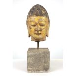A Tang style carved and parcel gilt head of Buddha, 20th century, modelled with stylised hair and