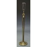 A brass standard lamp, late 19th, early 20th Century, with vase and flame finial top, inset with