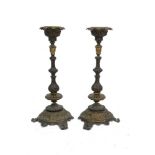 A pair of French bronze candlesticks, 19th century, the stems with heraldic shields, above writhen