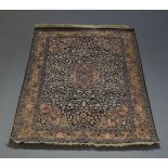 A Tabriz silk rug, early 20th Century, with pole medallion, in blue floral and foliate field,