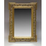 A gilt gesso wall mirror, early 20th Century, of rectangular form, with beveled plate set within a