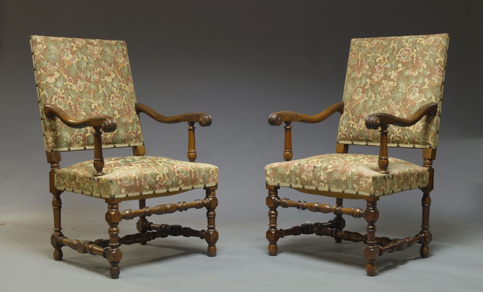 A pair of Flemish style walnut armchairs, 20th Century, the padded oblong backs above stuffed seats,