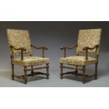 A pair of Flemish style walnut armchairs, 20th Century, the padded oblong backs above stuffed seats,