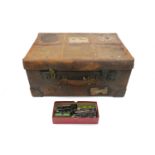A vintage leather suitcase with Cunard Line Class B "Cabin" luggage label to top, containing a