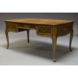 An mahogany and parcel gilt desk, early 20th Century, the rounded rectangular top inset with leather