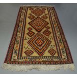 An Anatolian Kilim with three main lozenge medallions in straw coloured field, 315cm x 157cm,