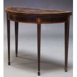 A George III mahogany and boxwood strung card table, the fold over demi-lune top enclosing claret